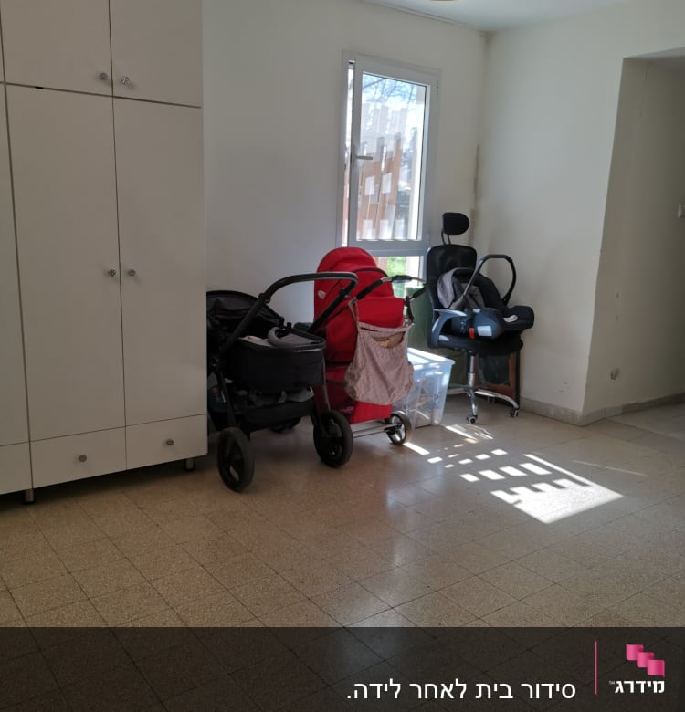 עגלות תינוק וארון לבן בחדר מואר